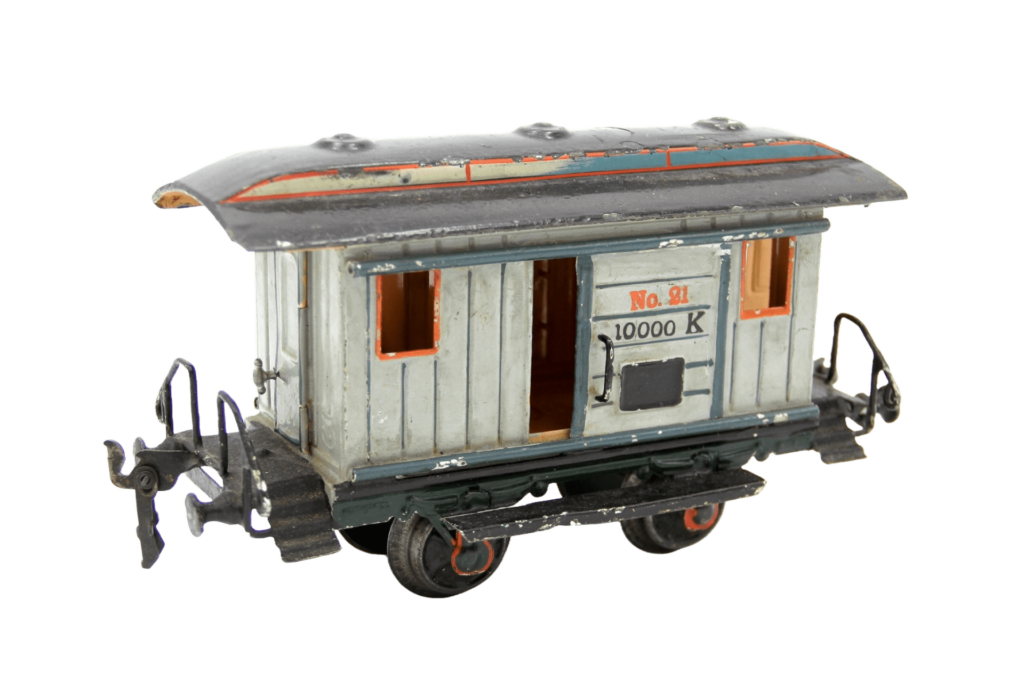 Miniatur-Gepäckwagen aus Blech mit grün-grauen Wänden, einem grauen Dach und Schiebetüren mit der Beschriftung No. 21, 10000 K.