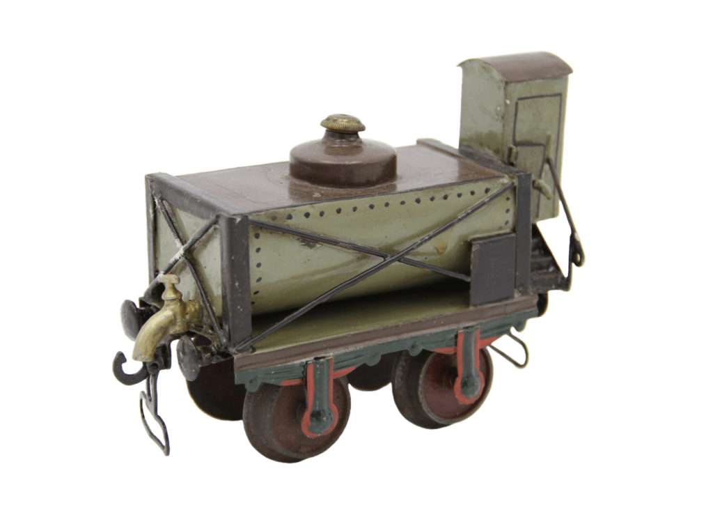 Modell eines Güterwagens mit offenem Rahmenfahrgestell und halb-zylindrischem Tankbehälter, an dem ein großer Hahn befestigt ist.